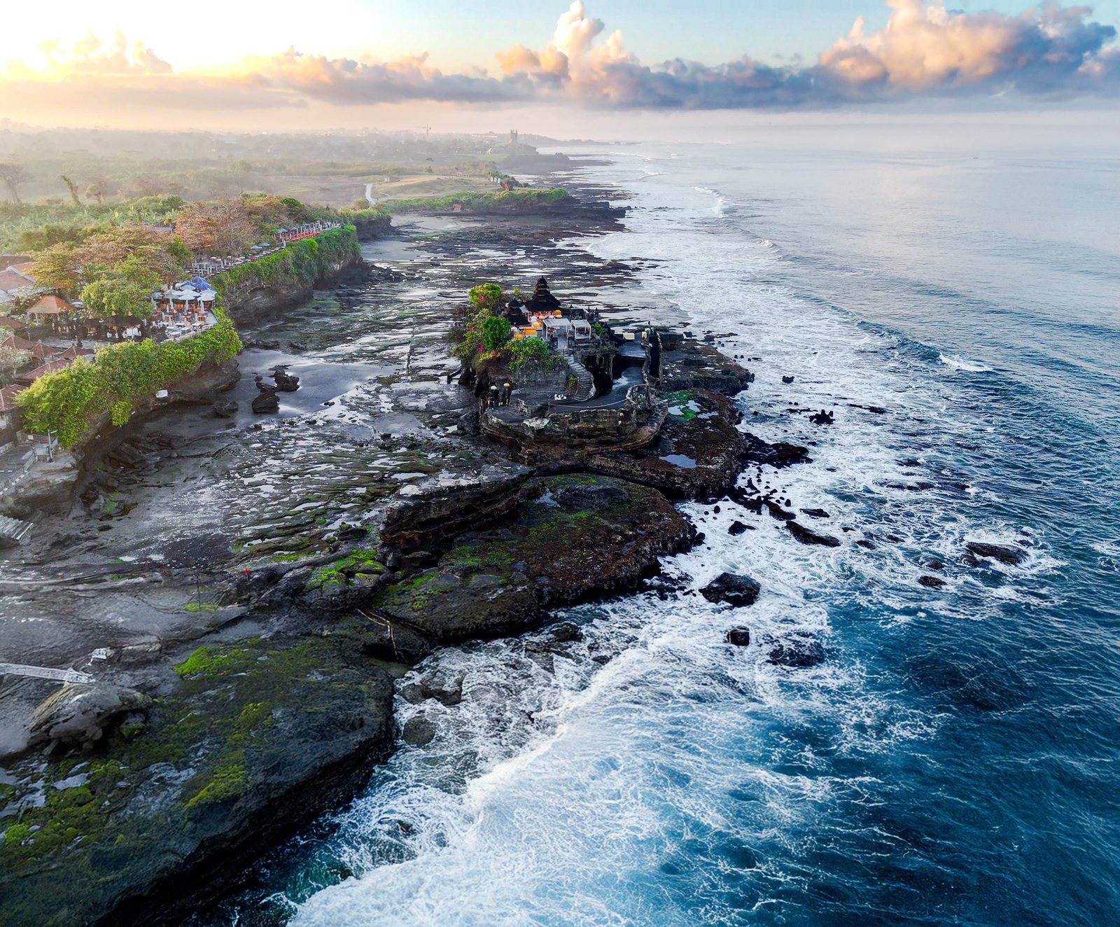 Tanah Lot sea temple on its rock with the surf breaking around it, from the air